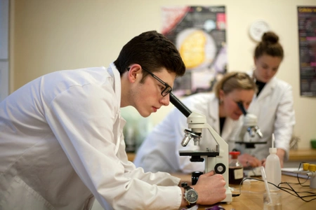 Students looking through microscopes in Biology